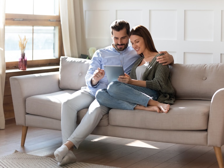 Couple On Couch Happy During Online Couples Counseling Session in California